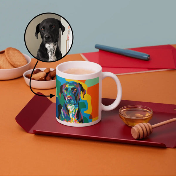 Colorful mug with a dog design on a table with cookies and honey dipper.